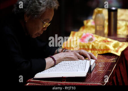 Buddha Tooth Relic Temple dans le quartier chinois. Femme à cérémonie bouddhiste. Singapour. Banque D'Images