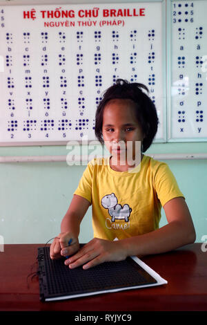 Centre pour enfants aveugles dirigées par des enfants. Girl écrit en braille. Ho Chi Minh ville. Le Vietnam. Banque D'Images