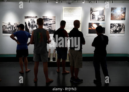 Musée des débris de guerre. Les visiteurs à la recherche de photos choquantes de la guerre. Ho Chi Minh Ville. Le Vietnam. Banque D'Images