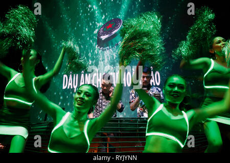 DJ sur scène et Heineken filles désignant foule danser dans une discothèque. Ho Chi Minh Ville. Le Vietnam. Banque D'Images
