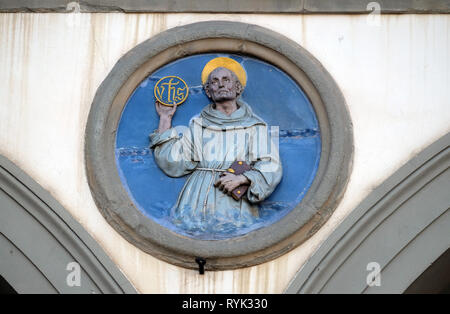 Saint Bernardino de Sienne, terre cuite vernissée tondo par Andrea della Robbia, situé entre les deux arches de l'ancien Ospedale di San Paolo, à Florence Banque D'Images