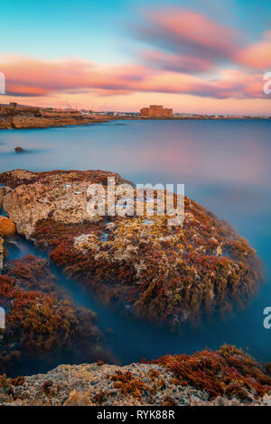 Belle longue exposition d'un coup de soleil seascape voir le château médiéval de Paphos et de la côte de la mer Banque D'Images