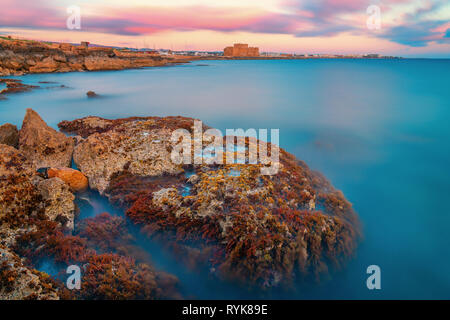 Belle longue exposition d'un coup de soleil seascape voir le château médiéval de Paphos et de la côte de la mer Banque D'Images