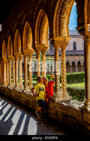 Jeune garçon de 12 ans avec sa mère dans le cloître de la cathédrale de Monreale, Sicile (Italie). Banque D'Images