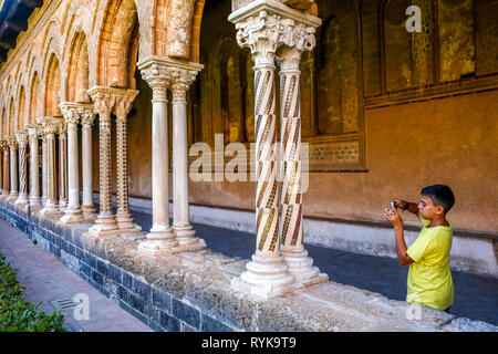 Jeune garçon de 12 ans de prendre une photo dans le cloître de la cathédrale de Monreale, Sicile (Italie). Banque D'Images