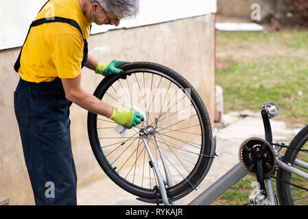 Nettoyage de l'homme son vélo pour la nouvelle saison de conduite Banque D'Images