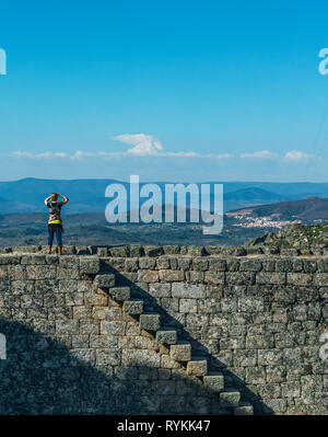 Femme debout sur le dessus de la colline de Monsanto remparts du château. Donnant sur la vue des montagnes, des villages et des plaines du Portugal et l'Espagne. Banque D'Images