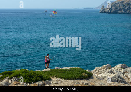 Rhodes, Grèce - 17 septembre 2017 : Сouple de jeunes fait une sur le bord de selfies la montagne contre l'azur mer Méditerranée Banque D'Images