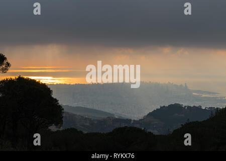 C'est une capture du coucher du soleil à Beyrouth capitale du Liban avec une couleur orange recouverte d'un brouillard épais et quelques nuages de pluie Banque D'Images