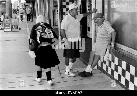 SENIORS SOUTH BEACH 1990S USA FLORIDE deux vieux hommes passant le temps de la journée bavarder pendant qu'une vieille femme passe à l'aide d'un bâton de marche South Beach Miami Floride 90s 1999 US HOMER SYKES Banque D'Images