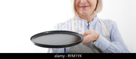 Serveuse femme cuisine vide donne la plaque noire pour vos produits publicitaires isolé sur fond blanc. Maquette pour une utilisation Banque D'Images