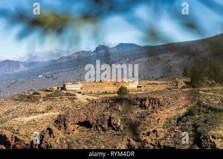 Voir dans le Barranco de Guaria et une ferme finca à distance au-dessus de la falaise, et les falaises de Los Gigantes sur l'horizon, à partir de Las Fuentes Banque D'Images