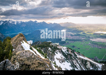 Paysage panoramique avec vue sur les montagnes enneigées et des nuages. Les rayons du soleil tombant sur valley de lacs et de petits villages en Bavière, Allemagne. Banque D'Images