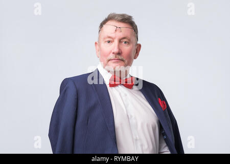 Young man wearing blue suit smiling chaudement et confiant. Banque D'Images