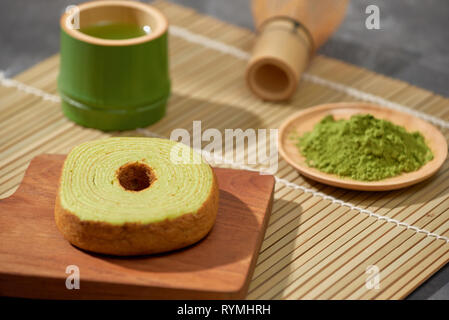 Thé vert matcha latte dans une tasse et cérémonie du thé ustensiles avec gâteau allemand. Copy space Banque D'Images