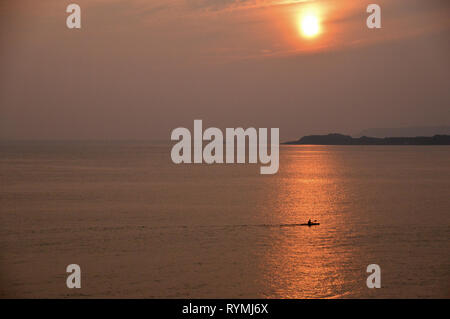 À l'Ouest à un seul Aviron Canoë à St Clement's Bay près de St Helier au coucher du soleil sur l'île de Jersey, Îles britanniques, Royaume-Uni. Banque D'Images