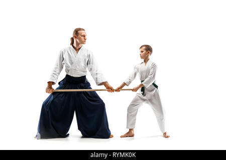 L'homme et teen boy combat avec sabre en bois à l'aïkido en école d'arts martiaux. Style de vie sain et de sport concept. Dans Fightrers kimono blanc sur fond blanc. Les hommes en uniforme de karaté. Banque D'Images