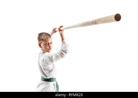 Teen boy combat avec sabre en bois à l'aïkido en école d'arts martiaux. Style de vie sain et de sport concept. Fightrer en kimono blanc sur fond blanc. L'homme en uniforme de karaté. Banque D'Images