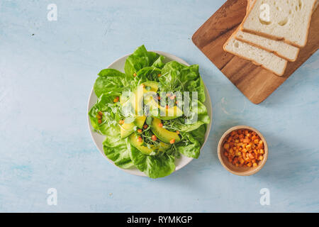 Salade verte en bonne santé de l'avocat, le concombre, les raisins, le persil et la salade avec vinaigrette huile d'olive, le vinaigre balsamique et la moutarde. Banque D'Images