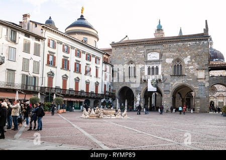 Bergame, ITALIE - février 23, 2019 : les touristes sur la Piazza Vecchia place avec fontaine Contarini et médiéval Palazzo della Ragione en Citta Alta (en haut Banque D'Images