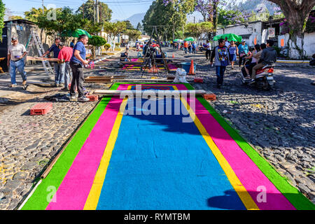 Antigua, Guatemala - Mars 11, 2018 : faire de la sciure tapis teints Carême pour être piétinés par les défilés en ville avec des célébrations de la Semaine Sainte Banque D'Images