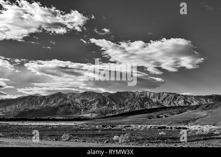 Noir et blanc, champs stériles et les montagnes sous le ciel du désert avec des nuages blancs. Banque D'Images