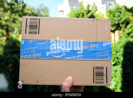 Paris, France - 11 juil 2018 : Man hand holding contre ville fond vert scotch d'étanchéité d'Amazone la livraison de colis Banque D'Images