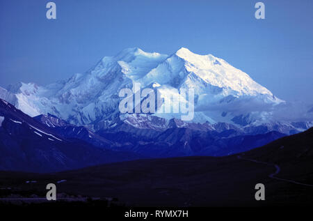 Parce que l'Alaska a 24 heures de lumière en été, même à minuit, c'est facile de voir les sommets majestueux Denali (anciennement Mont McKinley), qui est la plus haute montagne en Amérique du Nord à 20 310 pieds (6 190 mètres) et l'attraction principale du parc national de Denali et préserver dans l'Alaska, USA. La montagne a été officiellement donné son nom indien Athabascan d'origine par le président des États-Unis, Barack Obama, en 2015. Photo protégée par Michele & Tom Grimm. Banque D'Images