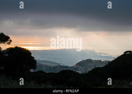 C'est une capture du coucher du soleil à Beyrouth capitale du Liban avec une couleur orange recouverte d'un brouillard épais et quelques nuages de pluie Banque D'Images