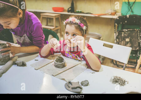 Deux jeunes fille à l'artiste peu leçon de poterie en atelier de céramique Banque D'Images