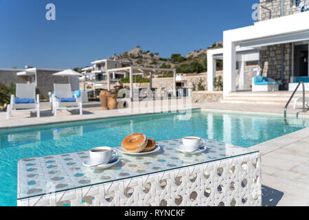 Des beignes et du café pour le petit-déjeuner pris à l'extérieur de la piscine Banque D'Images