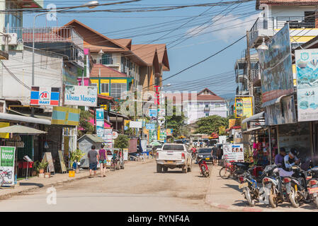 L'une des rues centrales de Vang Vieng Ville avec son architecture chaotique et l'abondance de signer les conseils de toutes sortes d'entreprises touristiques. Banque D'Images