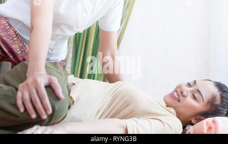 Happy women s'étirement des jambes au cours de massage thaïlandais Banque D'Images