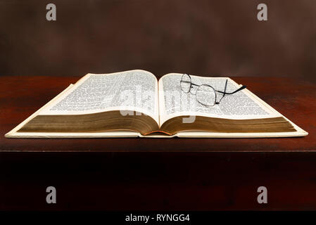 Gros plan horizontal d'une vieille Bible laissés ouverts sur un fond brun. Banque D'Images