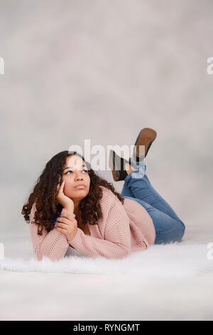 La haute école secondaire biracial attrayants portant sur marbre qui pose pour des portraits avec un air sérieux Banque D'Images