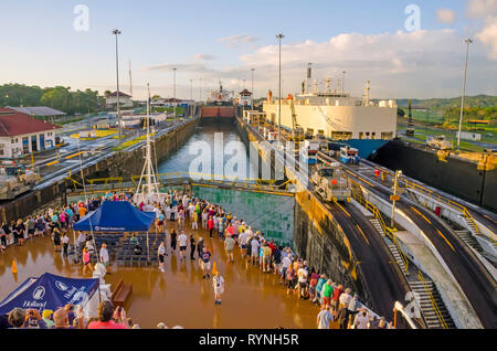 Les passagers des navires de croisière Canal de Panama sur proue du navire arrivent à l'entrée de Gatún juste après l'aube Banque D'Images