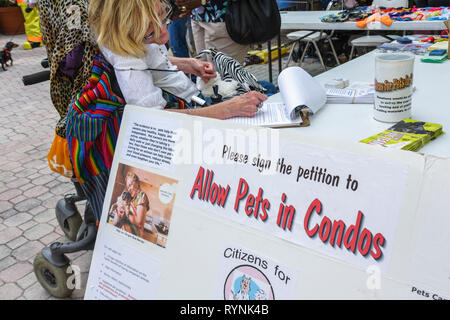 Miami Florida,Temple Israël,Bow Wow Palooza InterFaith Bénédiction des animaux,propriétaire,animal,signature,femme femmes,handicapés,fauteuil roulant,affiche,citoyen Banque D'Images