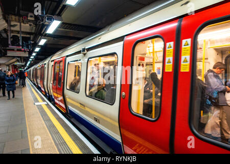 Tube de Londres train quitte la plate-forme à un endroit tranquille du temps de déplacement, après la fermeture des portes Banque D'Images