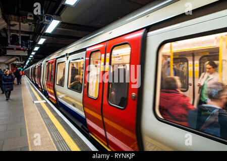 Tube de Londres train quitte la plate-forme à un endroit tranquille du temps de déplacement, après la fermeture des portes Banque D'Images