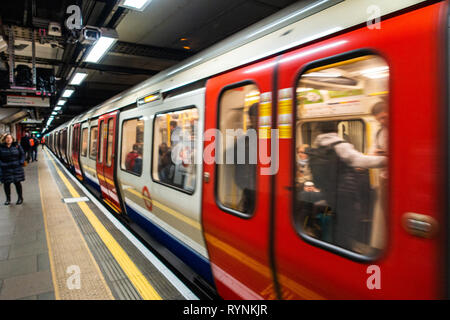 Tube de Londres train quitte la plate-forme à un endroit tranquille du temps de déplacement, après la fermeture des portes Banque D'Images