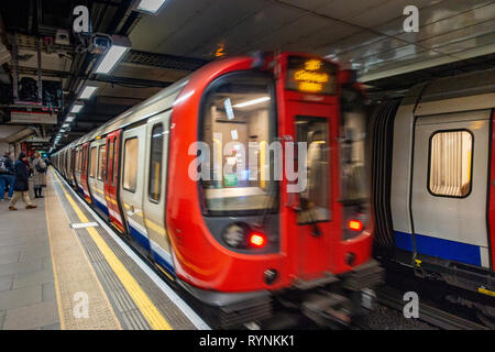 Tube de Londres train quitte la plate-forme à un endroit tranquille du temps de déplacement, après la fermeture des portes Banque D'Images