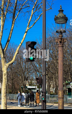 Feu de circulation, lanterne, arbre contre le ciel bleu de printemps à Paris, où les gens à pied par beau temps Banque D'Images