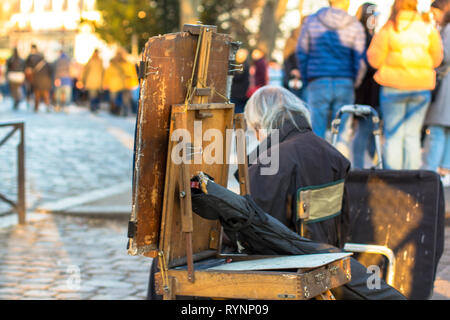 Artiste de rue aux cheveux gris assis et triste dans la rue Banque D'Images