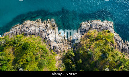 Vue de dessus, superbe vue aérienne d'une belle côte rocheuse tropicale avec palmiers baignée par une eau claire et turquoise, la liberté Beach, Phuket Banque D'Images