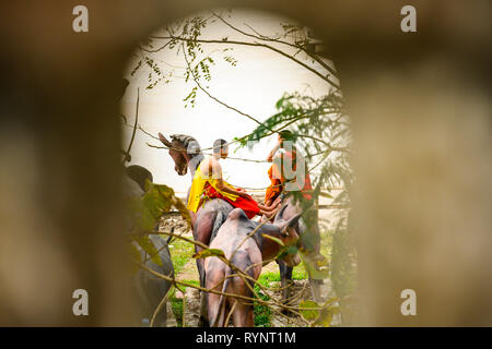 Deux moines bouddhistes assis sur un cheval sculpture parlons chaque autres à Luang Prabang, Laos. Banque D'Images