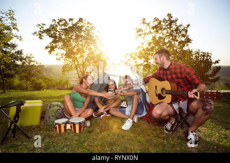 Jeunes amis on camping trip avec de la bière et de la musique, tout ce qu'il vous faut pour un bon moment Banque D'Images