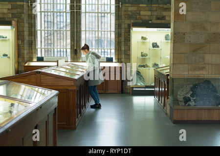 Une femme à l'écran de minéraux au Natural History Museum de Londres. UK Banque D'Images