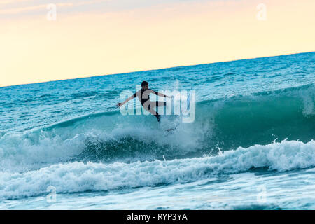 Surfer debout à Piha beach, New Zealand Banque D'Images