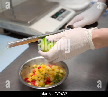 Zesting pâtissier la chaux dans coupe de fruits, cuisine commerciale Banque D'Images