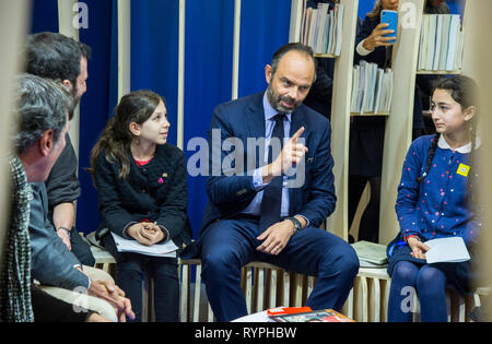 Le Premier ministre français Edouard Philippe vu parler avec l'enfant durant sa visite à la Foire du livre de Paris 2019. Banque D'Images